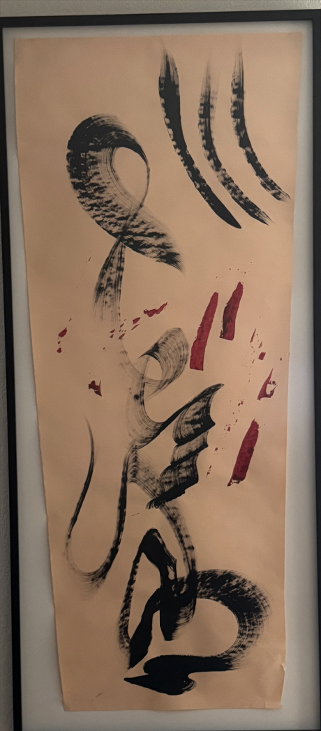 Abstract ink calligraphy in black and red strokes on a vertical tan paper background.